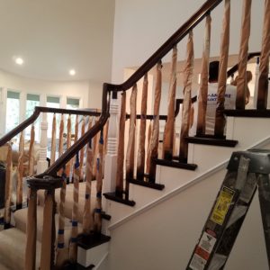 newly stained stairway handrail with masking